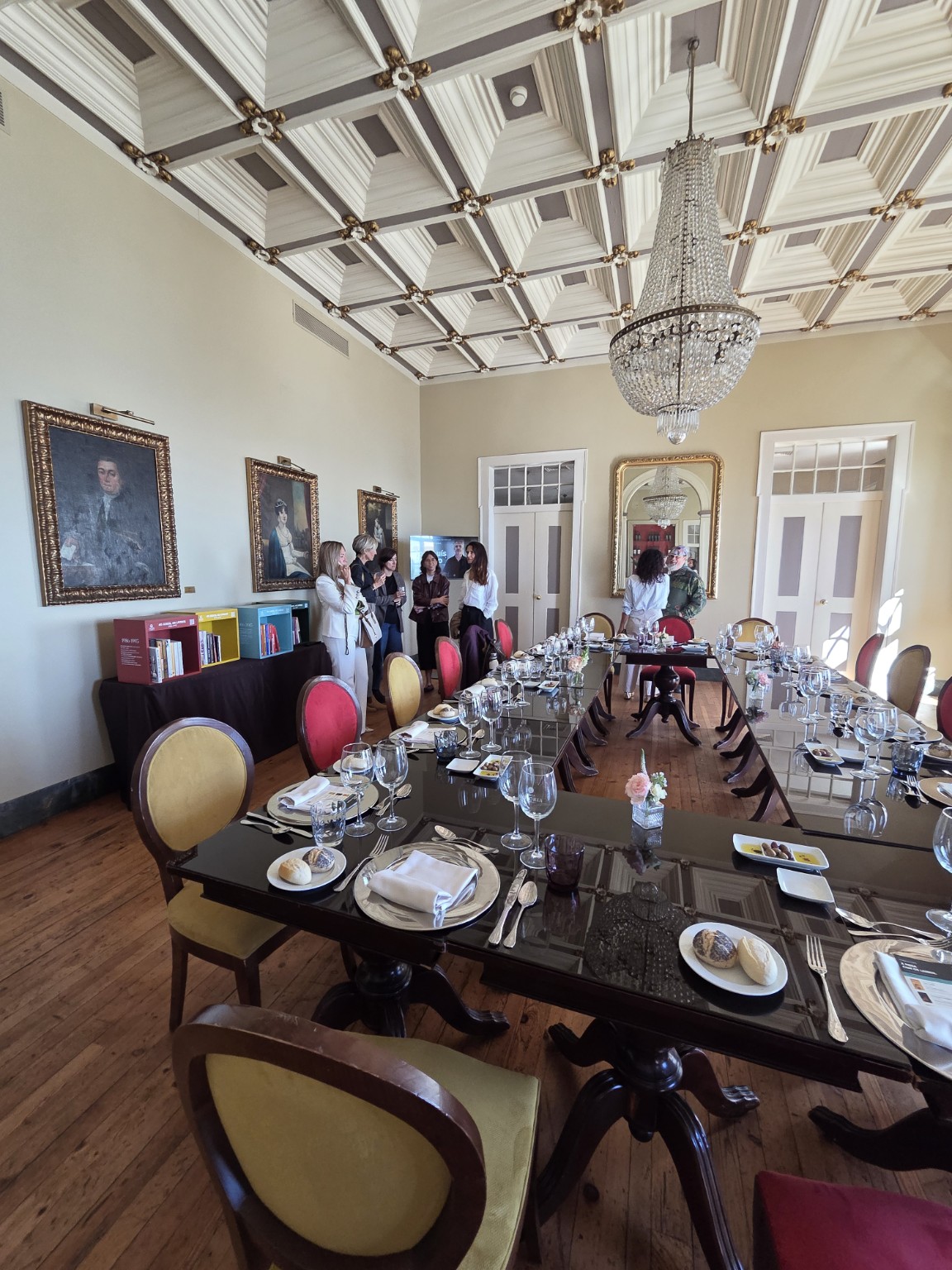 Convidados e biblioteca no salão do Palácio dos Arcos.